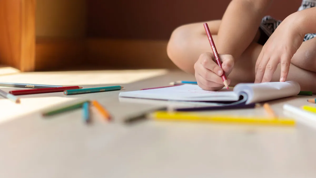 Defterine yazı yazan bir çocuk; okul uyumu ve pedagojik destek
